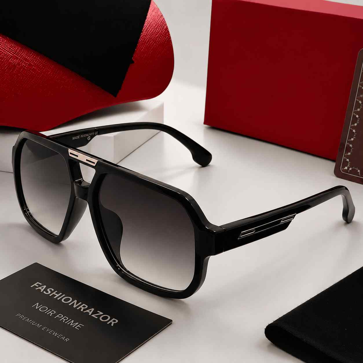Black sunglasses with a red box and card on a white surface